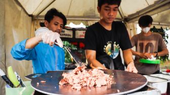 Pedagang menjual makanan saat bazar ramadhan di Monumen Pancasila Sakti, Lubang Buaya, Jakarta Timur, Minggu (24/4/2022). [Suara.com/Alfian Winanto]