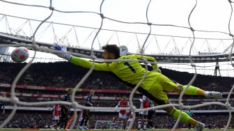 Penjaga gawang Manchester United David de Gea tidak bisa menahan tembakan jarak jauh dari pemain tengah Arsenal Granit Xhaka saat pertandingan sepak bola Liga Premier Inggris antara Arsenal dan Manchester United di Stadion Emirates, London, Inggris, Sabtu (23/4/2022). [Glyn KIRK / AFP]
