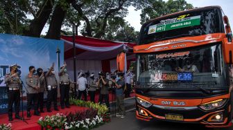 Dirlantas Polda Metro Jaya Kombes Pol Sambodo Purnono (kiri) bersama Kabid Humas Kombes Pol Endra Zulpan (kedua kiri) melepas bus berisi para pemudik dalam Mudik Gratis Polri 2022 di kompleks Gelora Bung Karno, Jakarta, Senin (25/4/2022). [ANTARA FOTO/Sigid Kurniawan/aww]