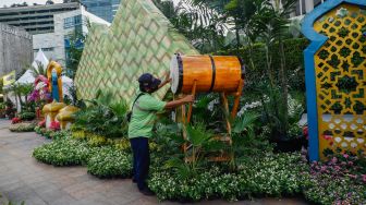 Petugas memasang hiasan bedug untuk ornamen bernuansa lebaran yang terpasang di kawasan Bundaran HI, Jakarta Pusat, Selasa (26/4/2022). [Suara.com/Alfian Winanto]