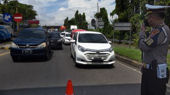 Personel Polantas menerapkan sistem buka tutup untuk kendaraan yang keluar dari Jalan Tol Tangerang - Merak di Jalan Cikuasa menuju Pelabuhan Merak, Banten, Rabu (27/4/2022). ANTARA FOTO/Asep Fathulrahman