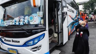 Calon penumpang menaiki bus antarkota antarprovinsi (AKAP) di Terminal Kampung Rambutan, Jakarta Timur, Rabu (27/4/2022). [Suara.com/Alfian Winanto]