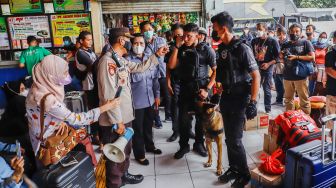 Tim K9 dari BNN melakukan pemeriksaan barang bawaan para pemudik di Terminal Kampung Rambutan, Jakarta Timur, Rabu (27/4/2022). [Suara.com/Alfian Winanto]