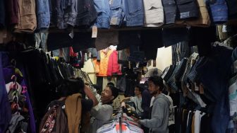 Calon pembeli memilih pakaian bekas layak pakai (thrifting) yang dijual di Pasar Kebayoran Lama, Jakarta, Kamis (28/4/2022). [Suara.com/Angga Budhiyanto]