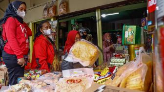 Pembeli memilih kue kering di salah satu toko kue kering di kawasan Ciracas, Jakarta Timur, Kamis (28/4/2022). [Suara.com/Alfian Winanto]