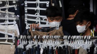 Calon pembeli memilih pakaian bekas layak pakai (thrifting) yang dijual di Pasar Kebayoran Lama, Jakarta, Kamis (28/4/2022). [Suara.com/Angga Budhiyanto]