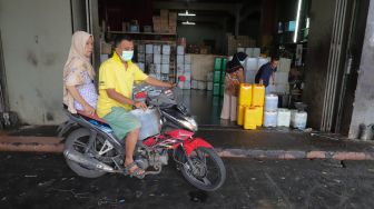 Penjual mengisi minyak goreng curah ke dalam jeriken di Kawasan Pasar Cipete, Jakarta Selatan, Jumat (29/4/2022). [Suara.com/Alfian Winanto]