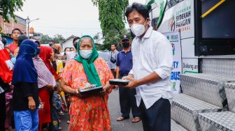 Pemimpin Redaksi Suara.com Suwarjono  memberikan bingkisan kepada warga saat aksi kemanusiaan di Kawasan Cipete Utara, Jakarta Selatan, Jumat (29/4/2022). [Suara.com/Alfian Winanto]