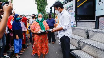 Pemimpin Redaksi Suara.com Suwarjono  memberikan bingkisan kepada warga saat aksi kemanusiaan di Kawasan Cipete Utara, Jakarta Selatan, Jumat (29/4/2022). [Suara.com/Alfian Winanto]