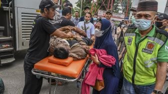 Seorang kerabat meratapi jenazah penumpang bus Sinar Jaya yang meninggal dunia di kawasan Simpang Jomin, Karawang, Jawa Barat, Sabtu (30/4/2022). ANTARA FOTO/Muhammad Adimaja
