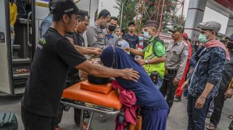 Seorang kerabat memeluk jenazah penumpang bus Sinar Jaya yang meninggal dunia di kawasan Simpang Jomin, Karawang, Jawa Barat, Sabtu (30/4/2022). ANTARA FOTO/Muhammad Adimaja
