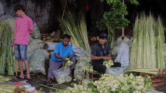 Pedagang menyelesaikan pembuatan kulit ketupat di Pasar Palmerah, Jakarta, Sabtu (30/4/2022). [Suara.com/Angga Budhiyanto]