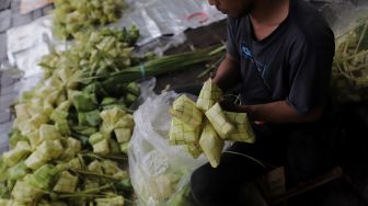 Pedagang menyelesaikan pembuatan kulit ketupat di Pasar Palmerah, Jakarta, Sabtu (30/4/2022). [Suara.com/Angga Budhiyanto]