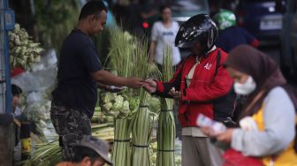 Pedagang kulit ketupat melayani pembeli di Pasar Palmerah, Jakarta, Sabtu (30/4/2022). [Suara.com/Angga Budhiyanto]