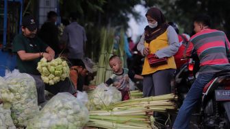 Pedagang kulit ketupat melayani pembeli di Pasar Palmerah, Jakarta, Sabtu (30/4/2022). [Suara.com/Angga Budhiyanto]