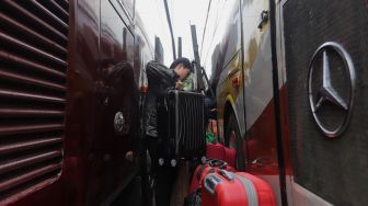 Penumpang memasukkan barang bawaan ke dalam bagasi bus di Terminal Kampung Rambutan, Jakarta, Sabtu (30/4/2022). [Suara.com/Angga Budhiyanto]