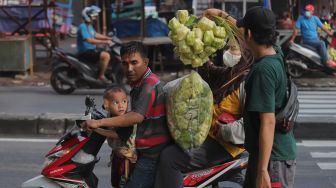 Pedagang kulit ketupat melayani pembeli di Pasar Palmerah, Jakarta, Sabtu (30/4/2022). [Suara.com/Angga Budhiyanto]