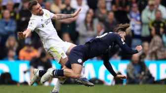 Gelandang Leeds United Stuart Dallas (kiri) dan gelandang Manchester City Jack Grealish (kanan) saling bertabrakan saat pertandingan sepak bola Liga Premier Inggris antara Leeds United dan Manchester City di Stadion Elland Road, Leeds, Inggris, Sabtu (30/4/2022). [Oli SCARFF / AFP]