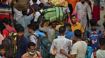 Orang-orang naik kapal feri untuk melakukan perjalanan mudik ke tempat asal mereka untuk merayakan Idul Fitri di Dhaka, Bangladesh, Sabtu (30/4/2022). [Munir uz Zaman / AFP]
