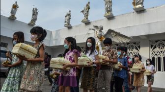 Sejumlah anak dari umat kristiani membawa paket ketupat Lebaran di Halaman Gereja Santo Yohanes Ciamis, Kampung Kerukunan, Lebak, Kabupaten Ciamis, Jawa Barat, Sabtu (30/4/2022). [ANTARA FOTO/Adeng Bustomi/hp]
