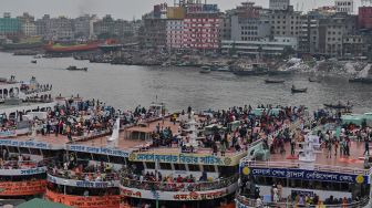 Orang-orang naik kapal feri untuk melakukan perjalanan mudik ke tempat asal mereka untuk merayakan Idul Fitri di Dhaka, Bangladesh, Sabtu (30/4/2022). [Munir uz Zaman / AFP]
