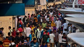 Orang-orang naik kapal feri untuk melakukan perjalanan mudik ke tempat asal mereka untuk merayakan Idul Fitri di Dhaka, Bangladesh, Sabtu (30/4/2022). [Munir uz Zaman / AFP]
