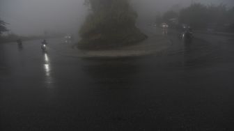 Kendaraan melintasi jalan yang tertutup kabut di Jalur Trans Sulawesi Kawasan Pegunungan Kebun Kopi di Kabupaten Parigi Moutong, Sulawesi Tengah, Sabtu (30/4/2022). [ANTARA FOTO/Mohamad Hamzah/hp]