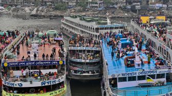 Orang-orang naik kapal feri untuk melakukan perjalanan mudik ke tempat asal mereka untuk merayakan Idul Fitri di Dhaka, Bangladesh, Sabtu (30/4/2022). [Munir uz Zaman / AFP]
