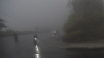Kendaraan melintasi jalan yang tertutup kabut di Jalur Trans Sulawesi Kawasan Pegunungan Kebun Kopi di Kabupaten Parigi Moutong, Sulawesi Tengah, Sabtu (30/4/2022). [ANTARA FOTO/Mohamad Hamzah/hp]