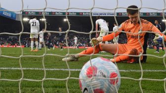 Penjaga gawang Leeds United Illan Meslier terpaku melihat bola masuk ke gawangnya saat pertandingan sepak bola Liga Premier Inggris antara Leeds United dan Manchester City di Stadion Elland Road, Leeds, Inggris, Sabtu (30/4/2022). [Oli SCARFF / AFP]