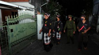 Pecalang bersama petugas Linmas memeriksa situasi rumah warga Muslim yang ditinggal mudik saat patroli di Denpasar, Bali, Sabtu (30/4/2022). [ANTARA FOTO/Nyoman Hendra Wibowo/hp]