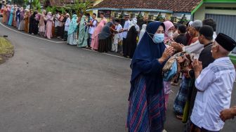 Sejumlah warga bersalaman usai melaksanakan shalat Idul Fitri 1443 Hijriyah di Desa Darmaraja, Kabupaten Ciamis, Jawa Barat, Senin (2/4/2022). [ANTARA FOTO/Adeng Bustomi/hp]