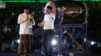 Gubernur DKI Jakarta Anies Baswedan (kiri) bernyanyi bersama penyanyi Pasha (kanan) pada acara Festival Tabuh Bedug Malam Takbiran di Jakarta International Stadium (JIS), Jakarta, Minggu (1/5/2022).  [ANTARA FOTO/Rivan Awal Lingga/nz]