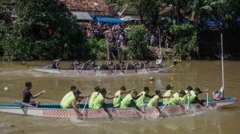 Sekelompok peserta berusaha mendayung perahunya saat mengikuti lomba perahu dayung tradisional di Sungai Sambong, Klidanglor, Kabupaten Batang, Jawa Tengah, Selasa (3/5/2022). [ANTARA FOTO/Harviyan Perdana Putra/nym]