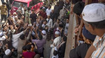 Sejumlah warga berebut uang yang dibagikan pada tradisi Lebaran Arab atau Iwwadh di Palu, Sulawesi Tengah, Selasa (3/5/2022).  ANTARA FOTO/Basri Marzuki
