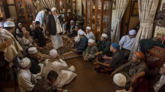 Sejumlah umat muslim keturunan Arab bersilaturahim dan berdoa di salah satu rumah yang dikunjungi pada tradisi Lebaran Arab atau Iwwadh di Palu, Sulawesi Tengah, Selasa (3/5/2022).  ANTARA FOTO/Basri Marzuki