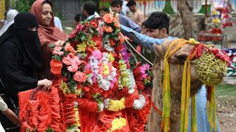 Warga Muslim bersiap menaiki unta yang dihias selama hari raya Idul Fitri di Islamabad, Pakistan, Selasa (3/5/2022). [Aamir QURESHI / AFP]