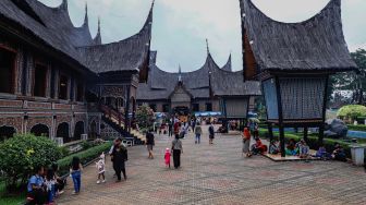 Pengunjung berwisata mengunjungi Anjungan Sumatera Barat di Taman Mini Indonesia Indah, Jakarta Timur, Rabu (4/5/2022). [Suara.com/Alfian Winanto]