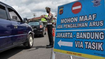 Personel Kepolisian mengatur arus lalu lintas kendaraan di Jalur Selatan Sindangkasih, Kabupaten Ciamis, Jawa Barat, Rabu (4/5/2022).  [ANTARA FOTO/Adeng Bustomi/nz]