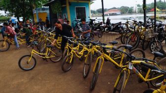 Pengunjung menyewa sepeda untuk berkeliling di Taman Mini Indonesia Indah, Jakarta Timur, Rabu (4/5/2022). [Suara.com/Alfian Winanto]
