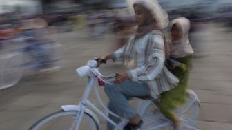 Warga menaiki sepeda saat berwisata di Taman Fatahillah, Kota Tua, Jakarta, Kamis (5/5/2022). [Suara.com/Angga Budhiyanto]