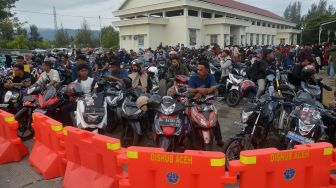 Sejumlah calon penumpang yang membawa kendaraan roda dua antre menunggu jadwal keberangkatan di pelabuhan penyeberangan Ulee Lheue, Banda Aceh, Aceh, Kamis (5/5/2022). [ANTARA FOTO/Ampelsa]