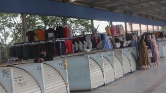 Warga berdiri di dekat deretan kios yang tutup di Skybridge Tanah Abang, Jakarta, Kamis (5/5/2022). [Suara.com/Angga Budhiyanto]