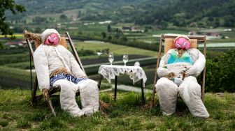 Dua orang-orangan sawah dipajang di ladang saat acara 'Pameran Orang-orangan Sawah' tahunan yang digelar di desa Castellar, Cuneo, Italia, Selasa (3/5/2022). [MARCO BERTORELLO / AFP]
