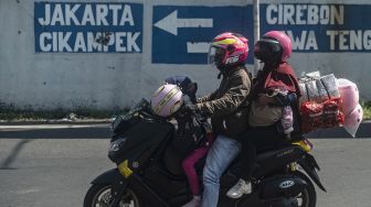 Pemudik dengan sepeda motor melintas di kawasan Simpang Jomin menuju arah Jakarta di Karawang, Jawa Barat, Kamis (5/5/2022). [ANTARA FOTO/Aprillio Akbar]