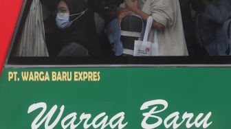 Pemudik bersiap turun dari bus setibanya di Terminal Kampung Rambutan, Jakarta, Sabtu (7/5/2022). [Suara.com/Angga Budhiyanto]