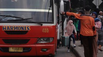 Pemudik membawa barang bawaan setibanya di Terminal Kampung Rambutan, Jakarta, Sabtu (7/5/2022). [Suara.com/Angga Budhiyanto]