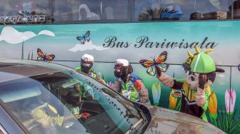 Polwan bersama badut karakter menghibur wisatawan yang terjebak kemacetan di jalur wisata Puncak, Gadog, Kabupaten Bogor, Jawa Barat, Sabtu (7/5/2022). ANTARA FOTO/Yulius Satria Wijaya