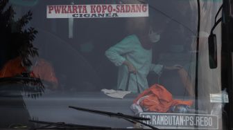 Pemudik membawa barang bawaan setibanya di Terminal Kampung Rambutan, Jakarta, Sabtu (7/5/2022). [Suara.com/Angga Budhiyanto]