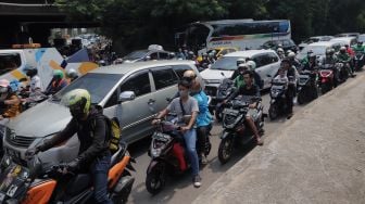Sejumlah kendaraan terjebak kemacetan di Jalan Raya Kalimalang, Bekasi, Jawa Barat, Sabtu (7/5/2022). [Suara.com/Angga Budhiyanto]